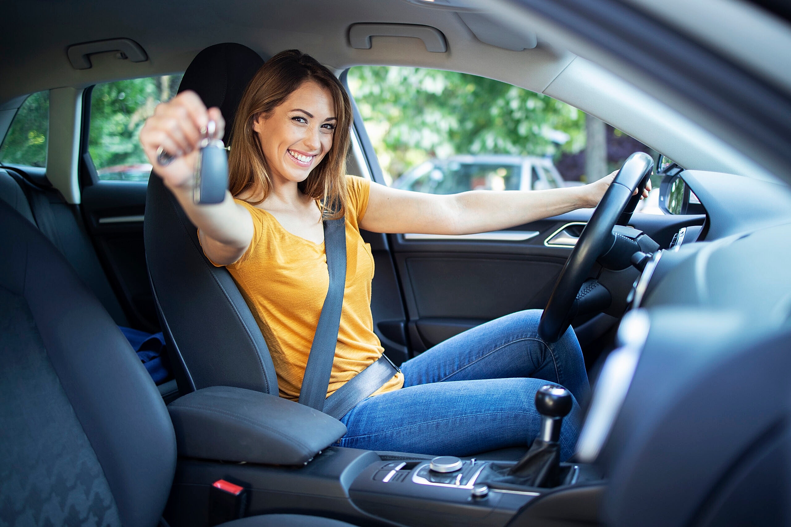 Beautiful female women driver sitting in her vehicle and holding car keys ready for a drive. Beautiful female women driver sitting in her vehicle and holding car keys ready for a drive.